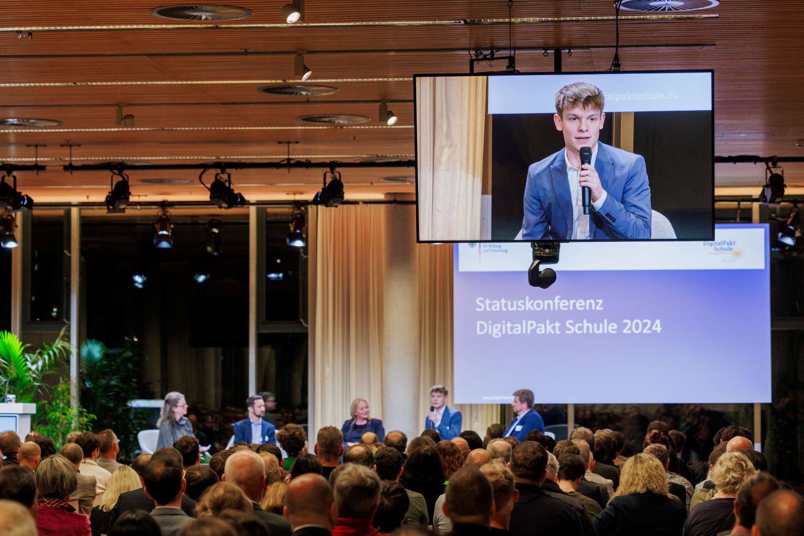 Schülervertreter spricht bei Plenum bei der Statuskonferenz DigitalPakt Schule 2024