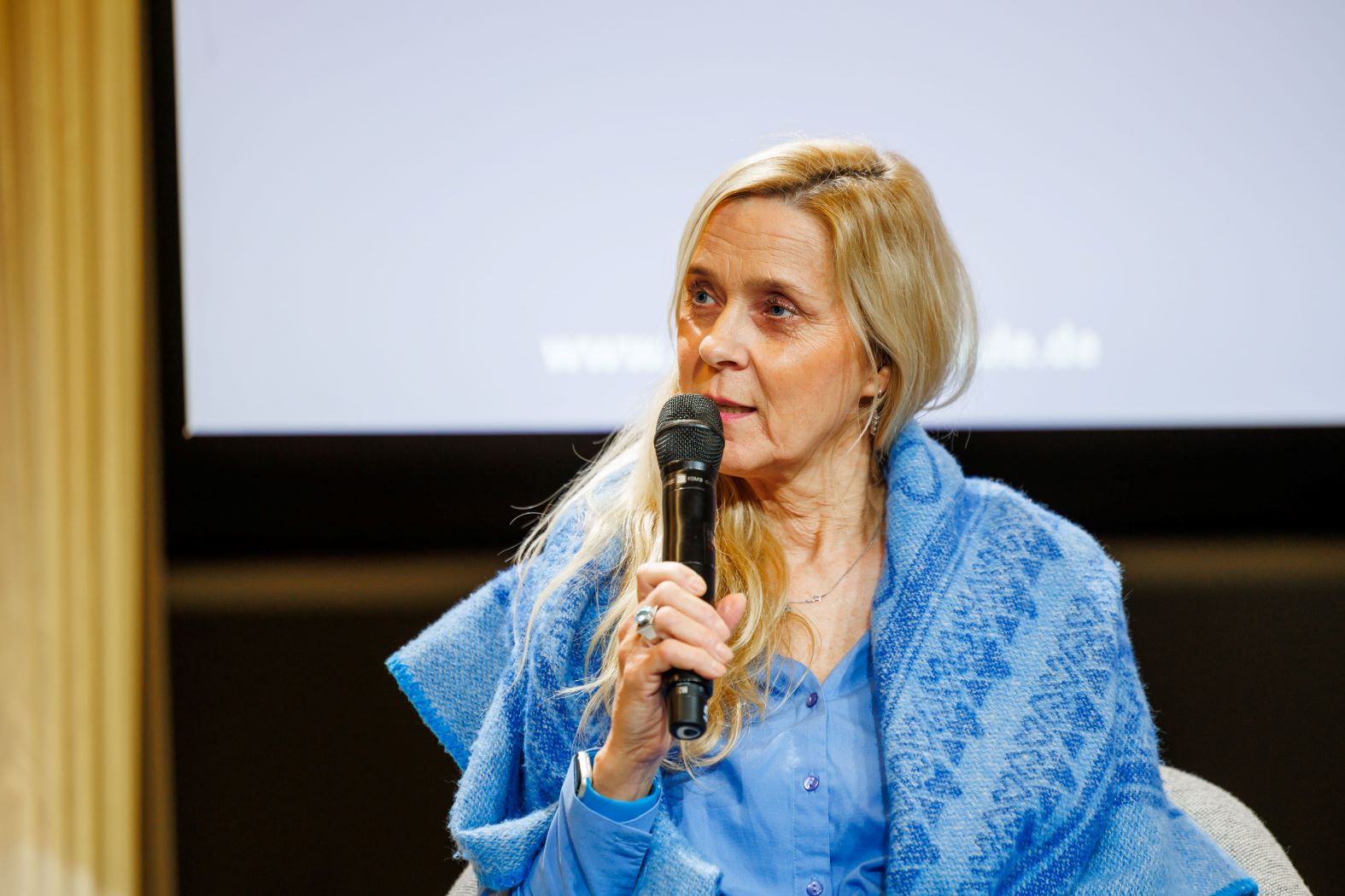 Frau spricht auf Plenum bei der Statuskonferenz DigitalPakt Schule 2024