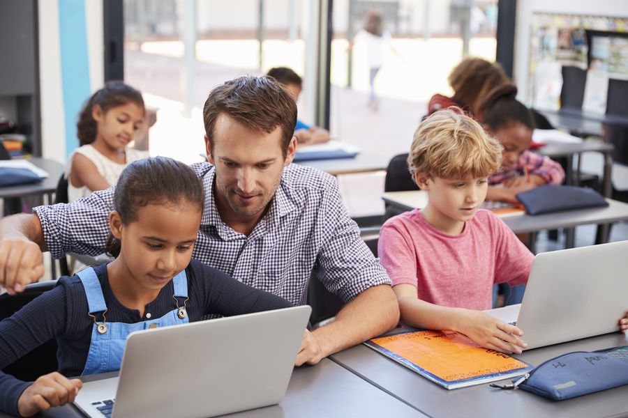 Lehrer und Schüler mit Laptops
